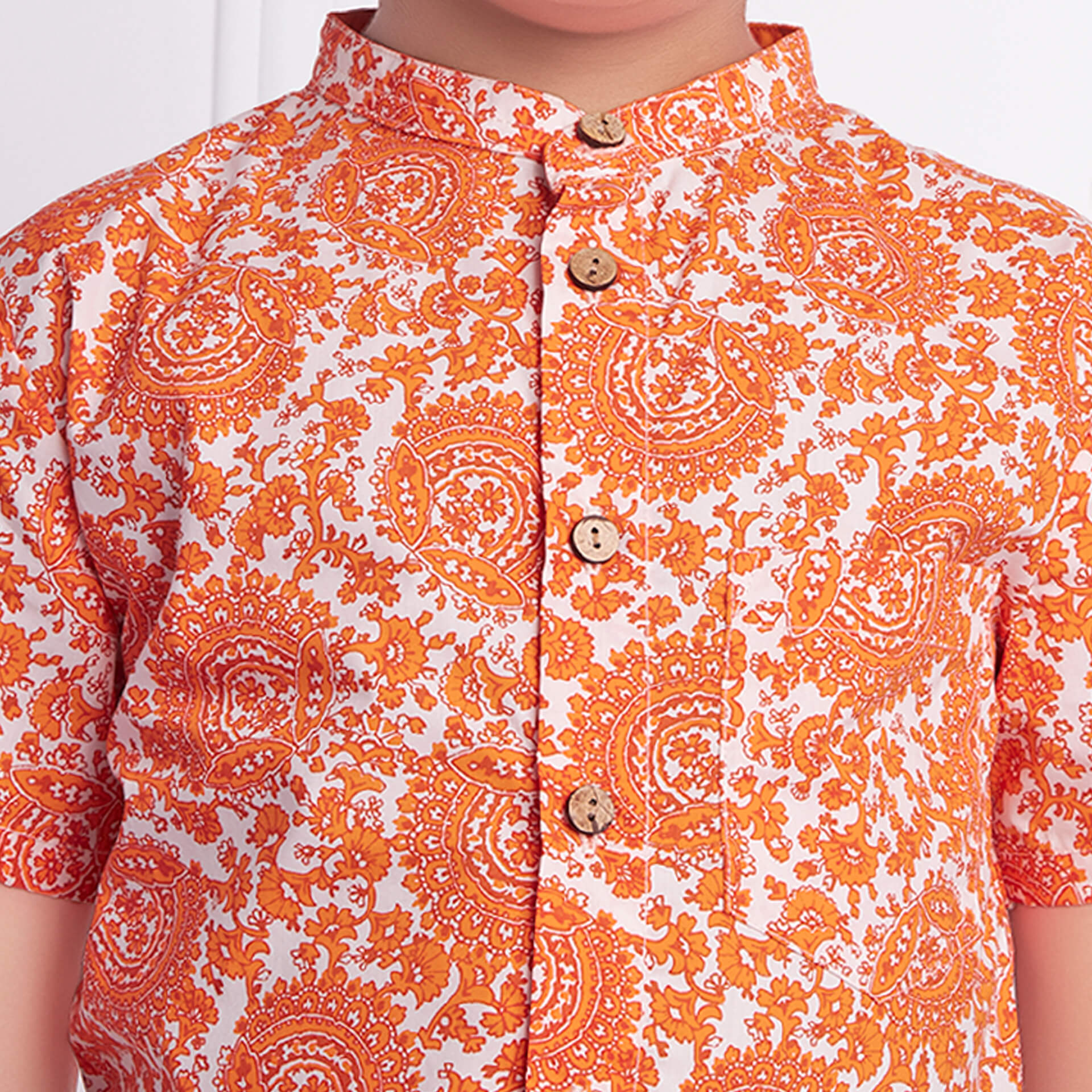 Detail on boys ethnic print shirt with mandarin collar and wood buttons