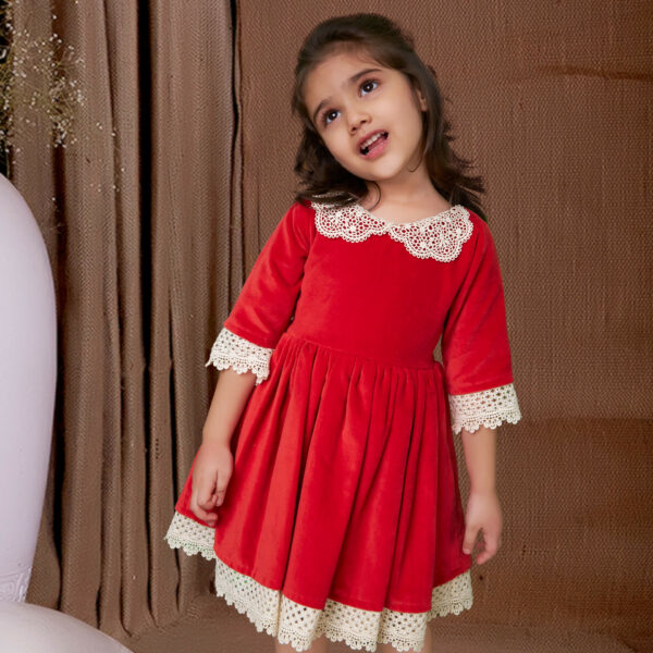 Cute girl poses in red velvet dress with white lace trims and elasticated waist