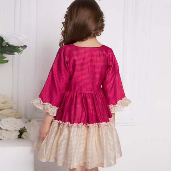 Girl seen from behind wearing a pink and ivory chanderi ruffle dress