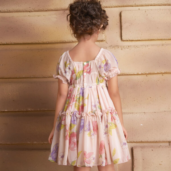 Back view of a girl wearing a pink floral printed chiffon ruffle dress