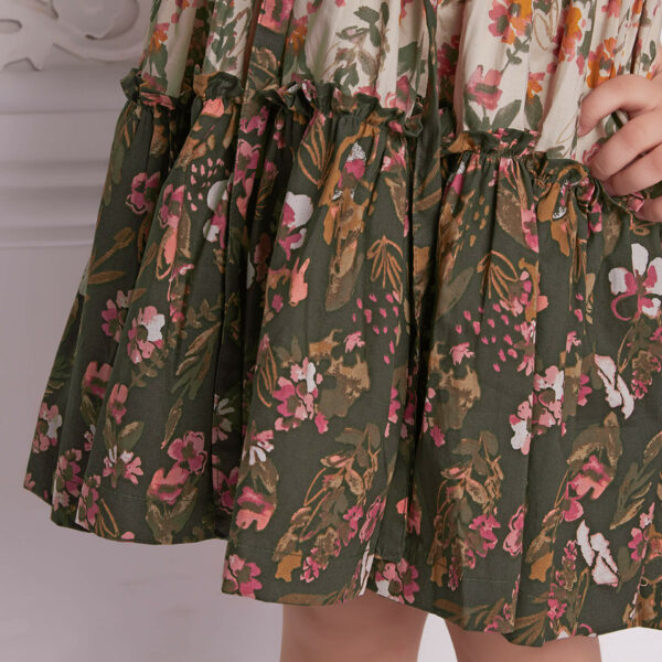 Closeup of the ruffle in a beige and green floral printed dress