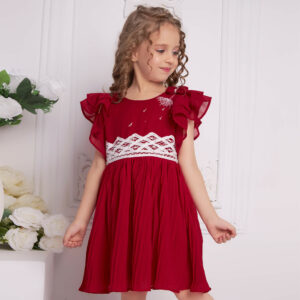 A curly haired girl posing in red chiffon battenburg lace embroidered dress