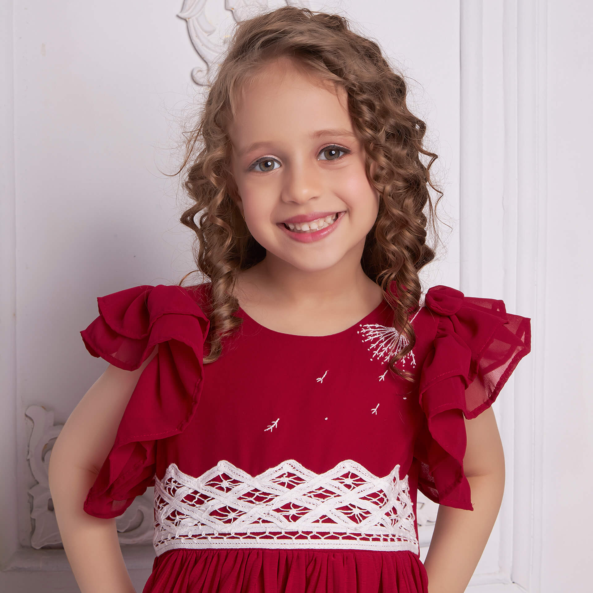 Close up of a smiling girl in a red chiffon battenburg lace dress