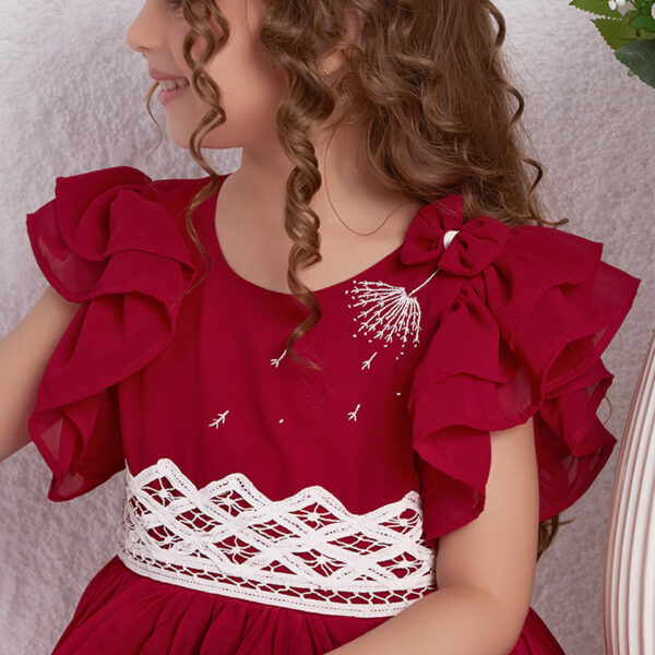 Close up of a girl in a red chiffon battenburg lace dress with pleated skirt