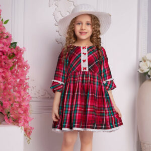 Hat-topped, a child wears a red plaid dress with white trims