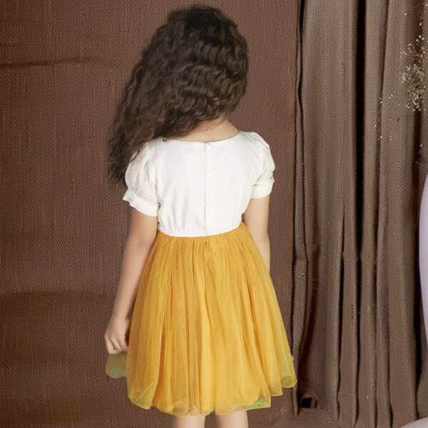 Back view of a mustard tulle dress with button fastening and an elasticated waist
