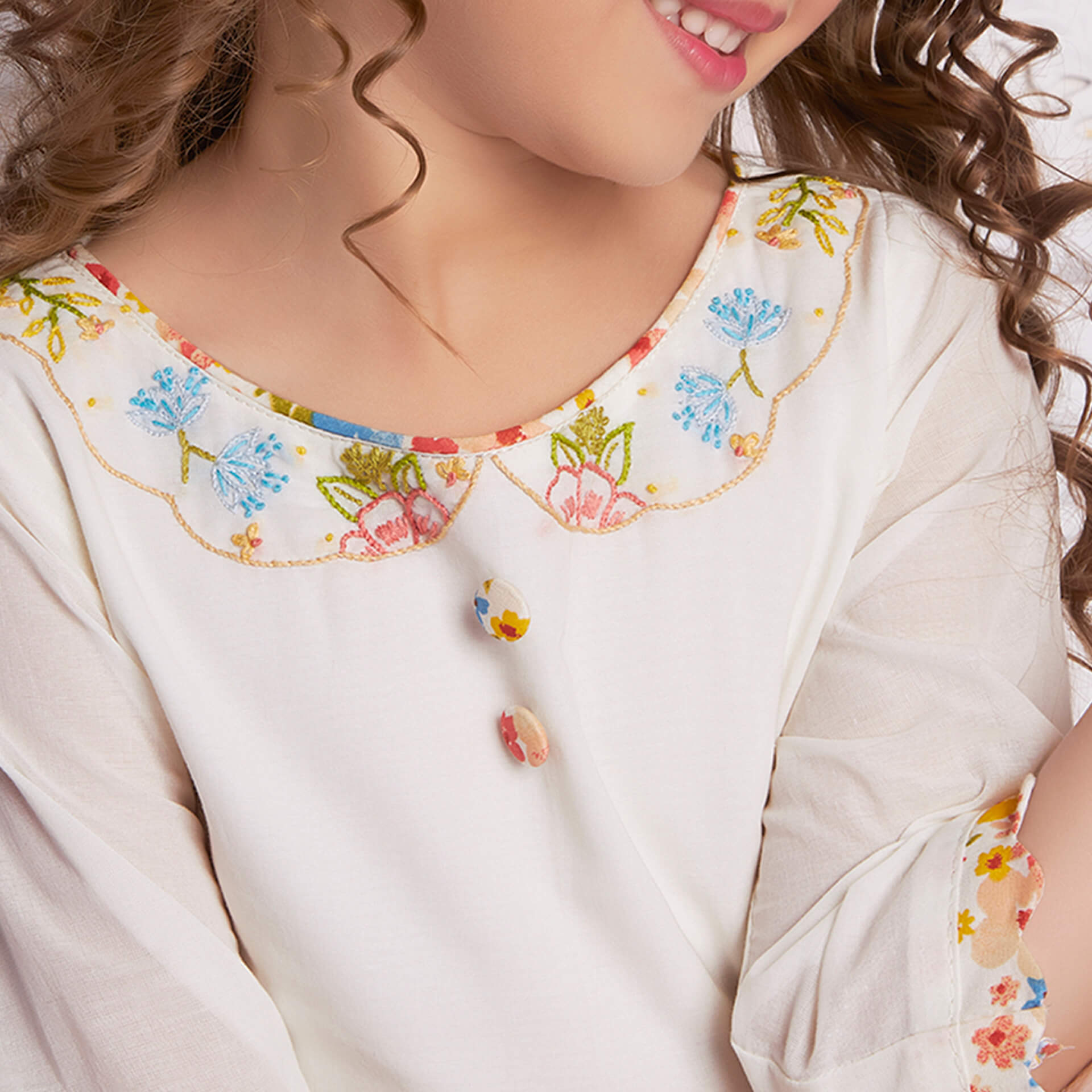 Detailed close-up of the embroidery on the neckline of white dress