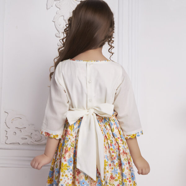 Back view of a girl wearing an ivory floral embroidered dress
