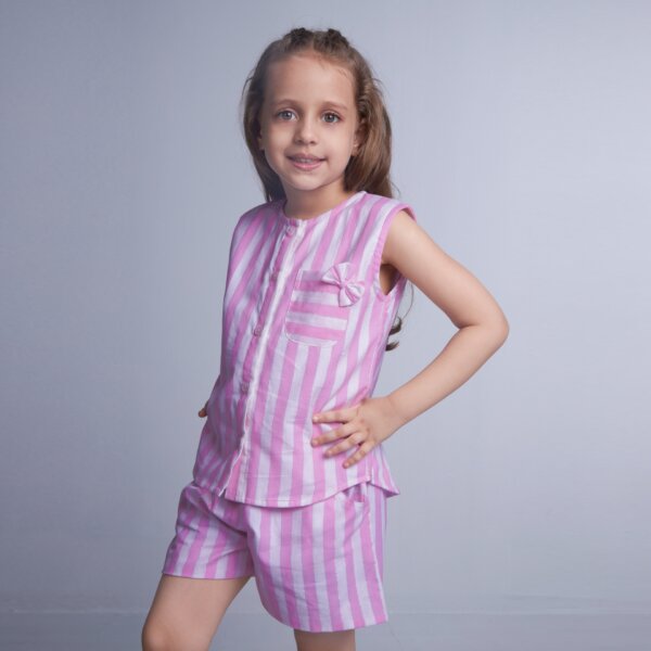 From the side, a girl showcases pink striped sleeveless co-ords set with pockets