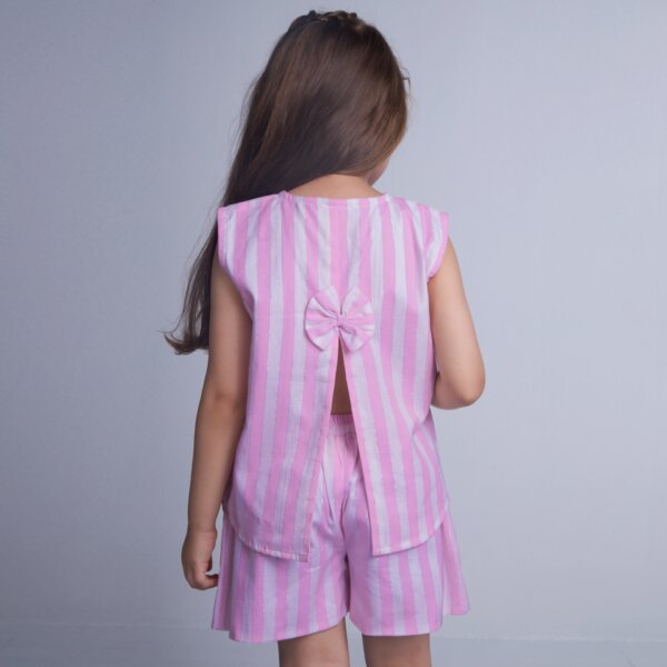 A girl is seen from the back, wearing a pink striped sleeveless blouse with a slit at the back, paired with shorts