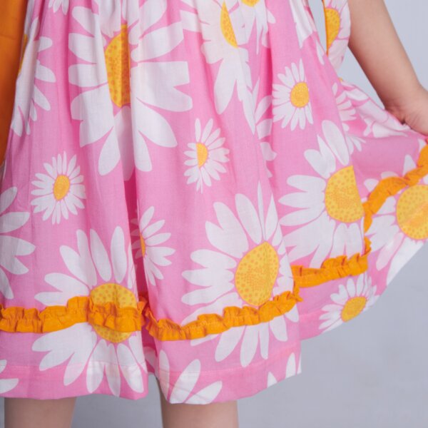 Close up of ruffles in a sleeveless pink floral printed dress