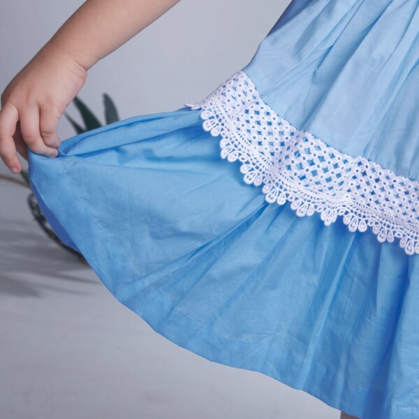 Detailed shot of delicate lace in a blue ombre embroidered dress