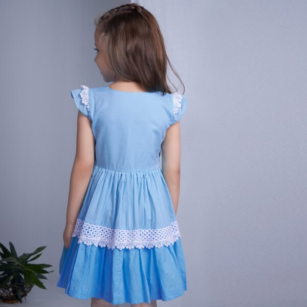 Back view of a girl wearing an ivory chiffon floral embroidered smock dress