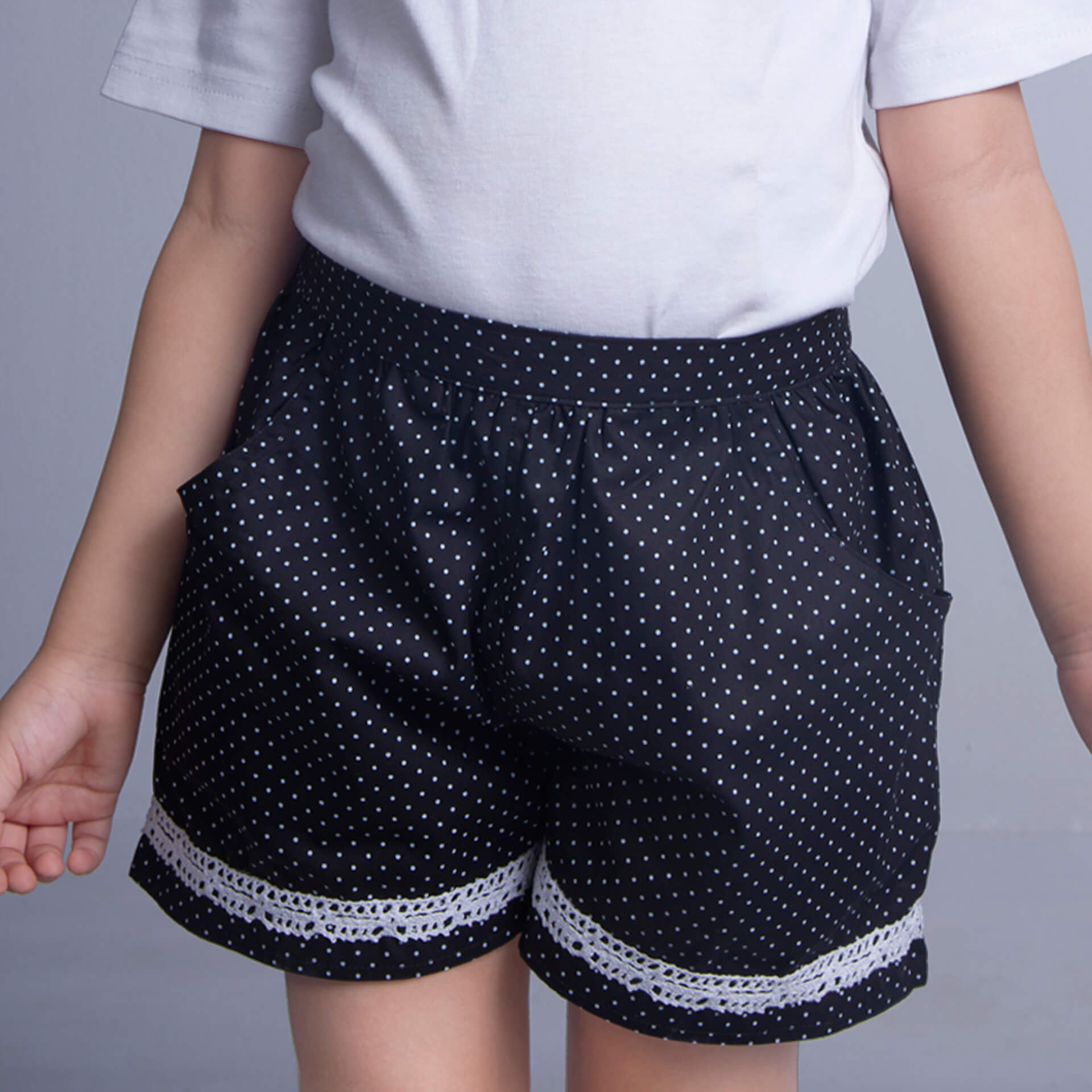 Black shorts in dot printed fabric with side pockets and contrast trims