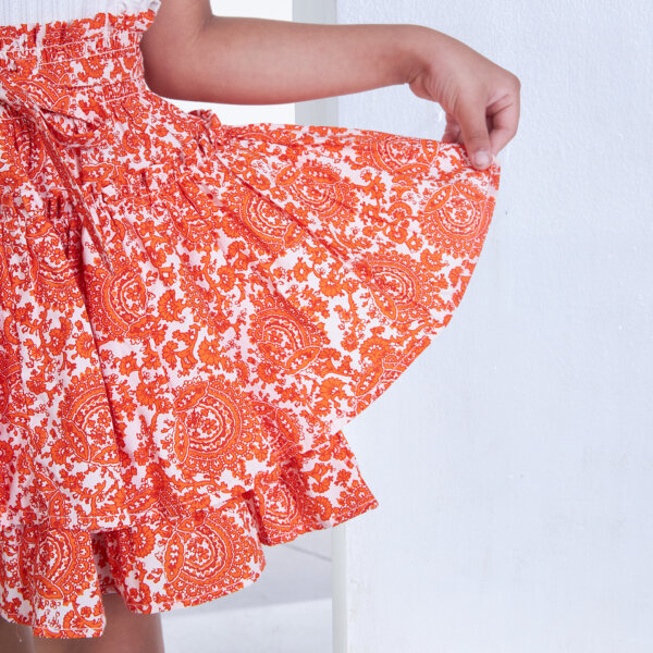 A close-up of the orange floral printed skirt layer
