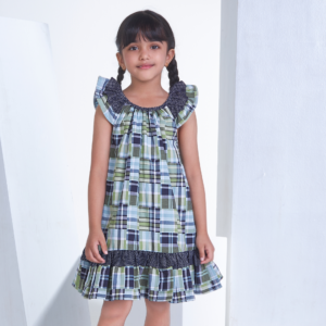 A girl dressed patch printed fabric dress in tones of navy, turquoise and green