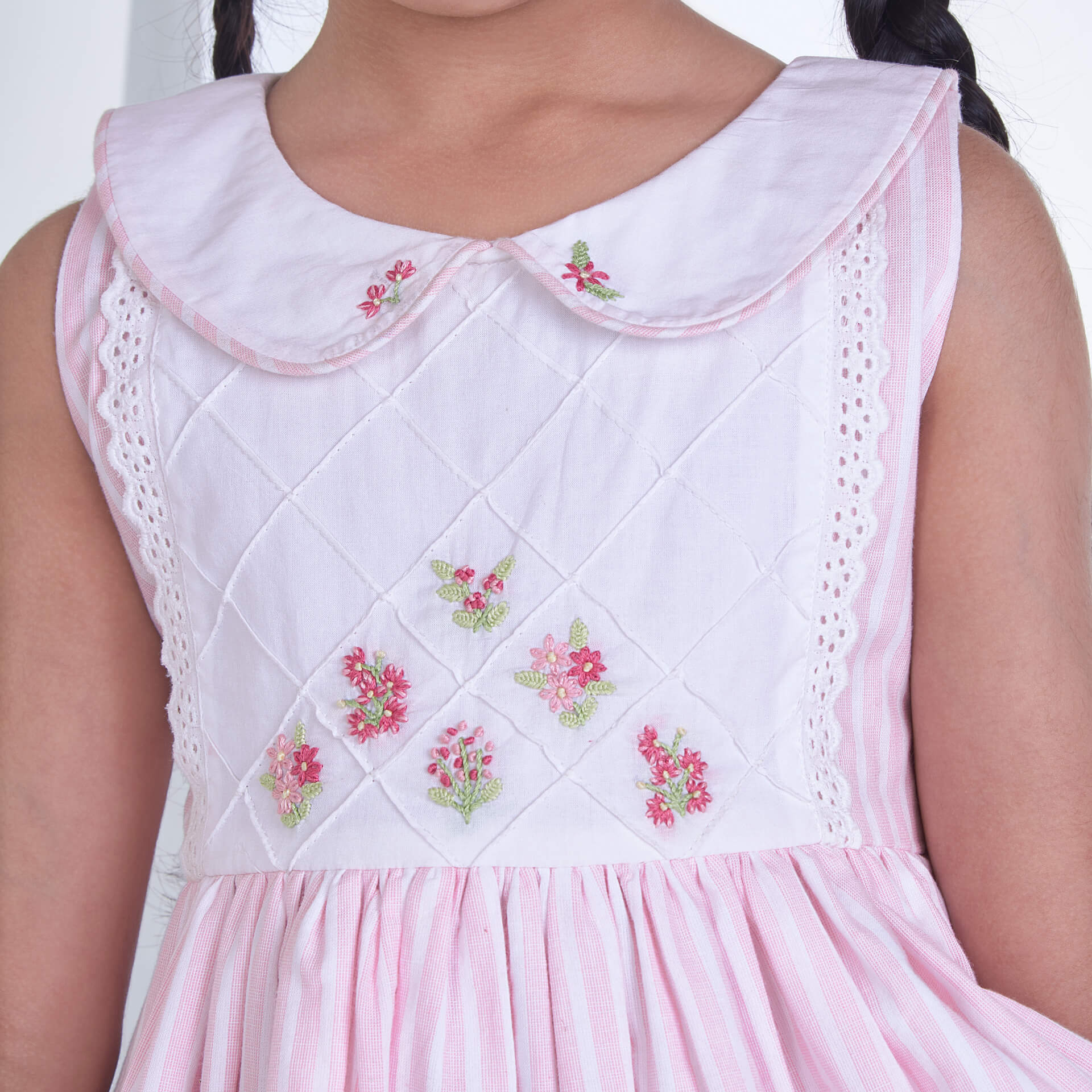Closeup of the embroidery on a pink striped collared dress