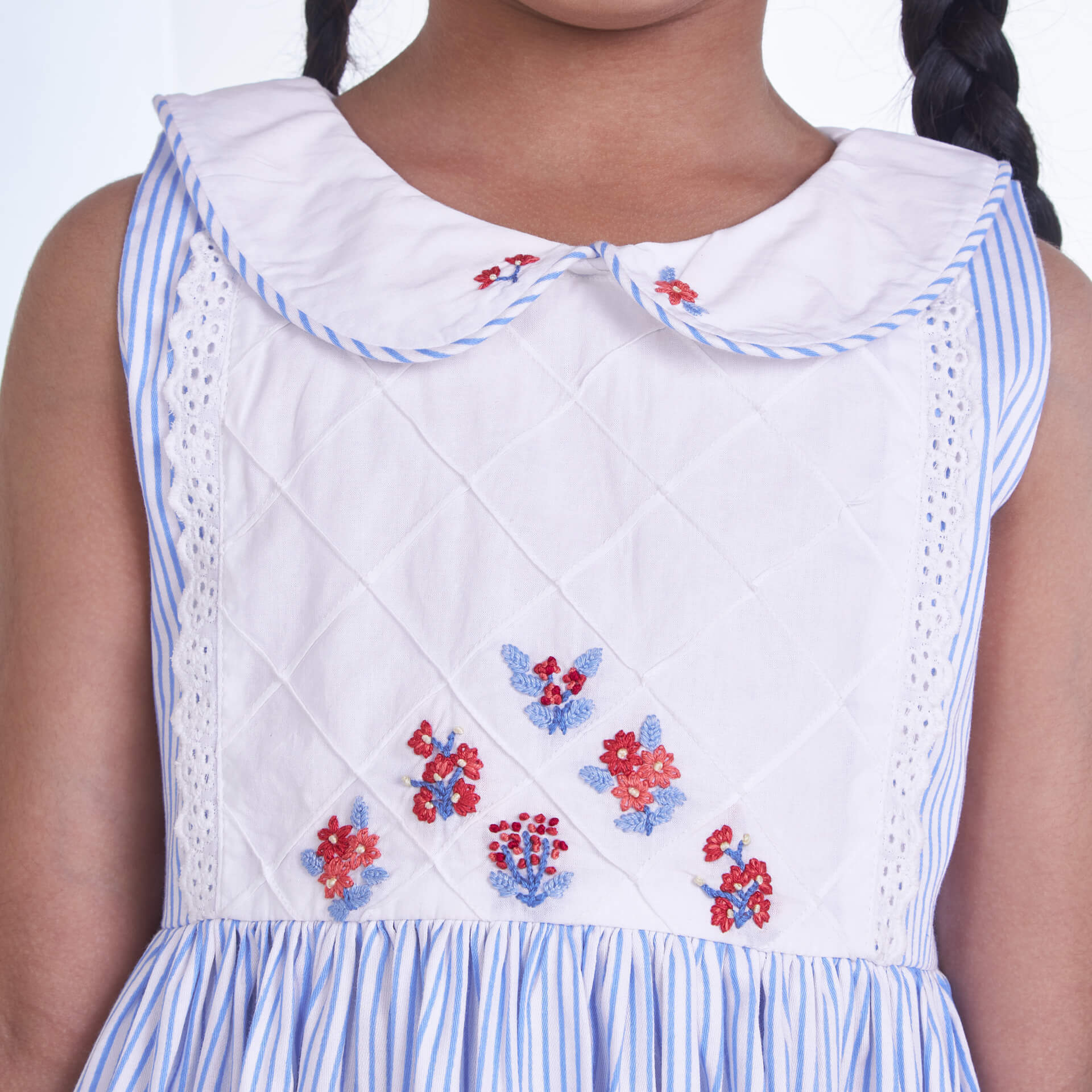 Closeup of the embroidery on a blue striped collared dress